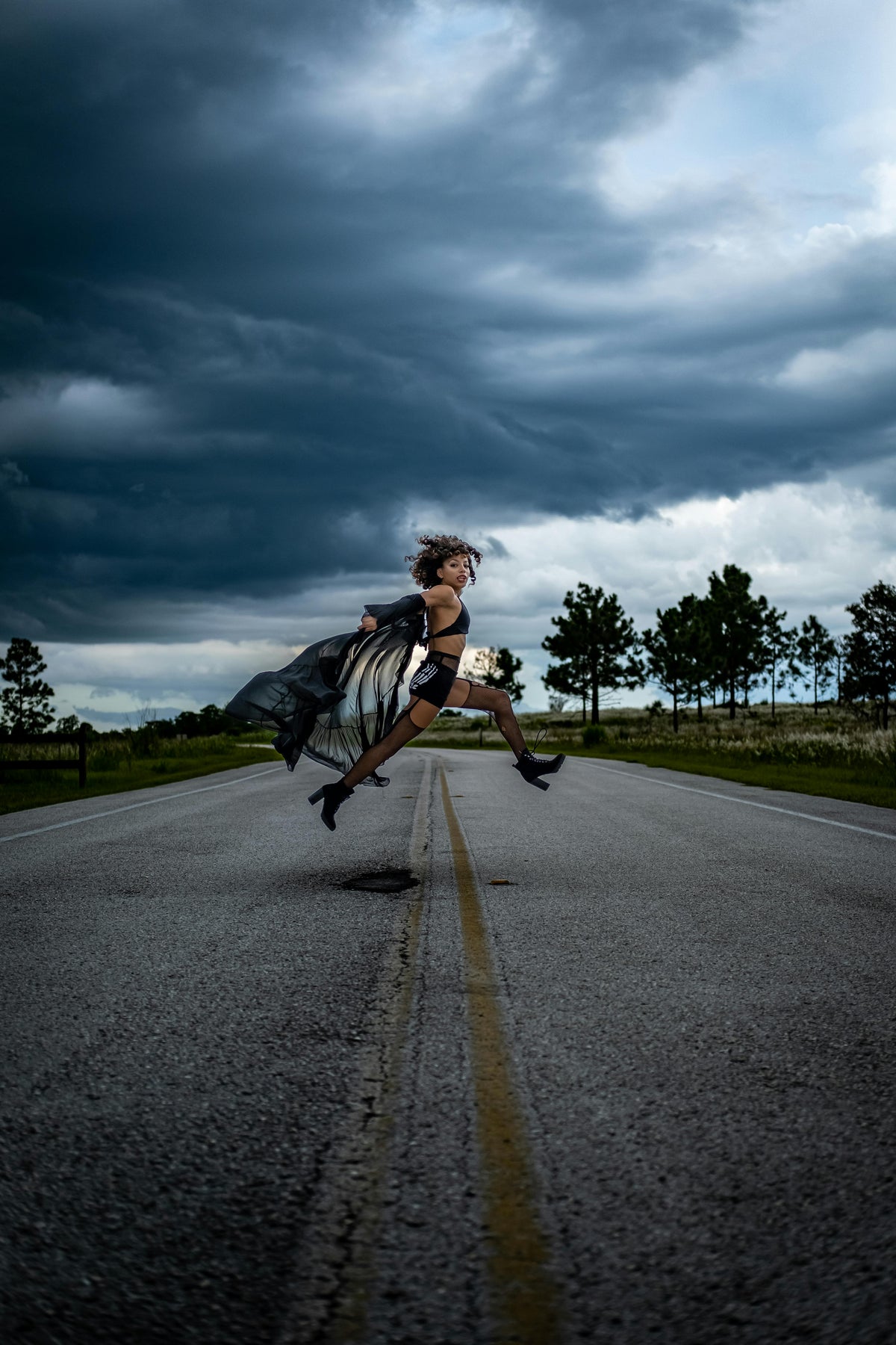 Woman jumping on open road representing energy and vitality