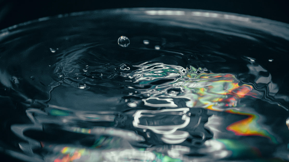Dark water macro with colorful light representing cellular hydration science