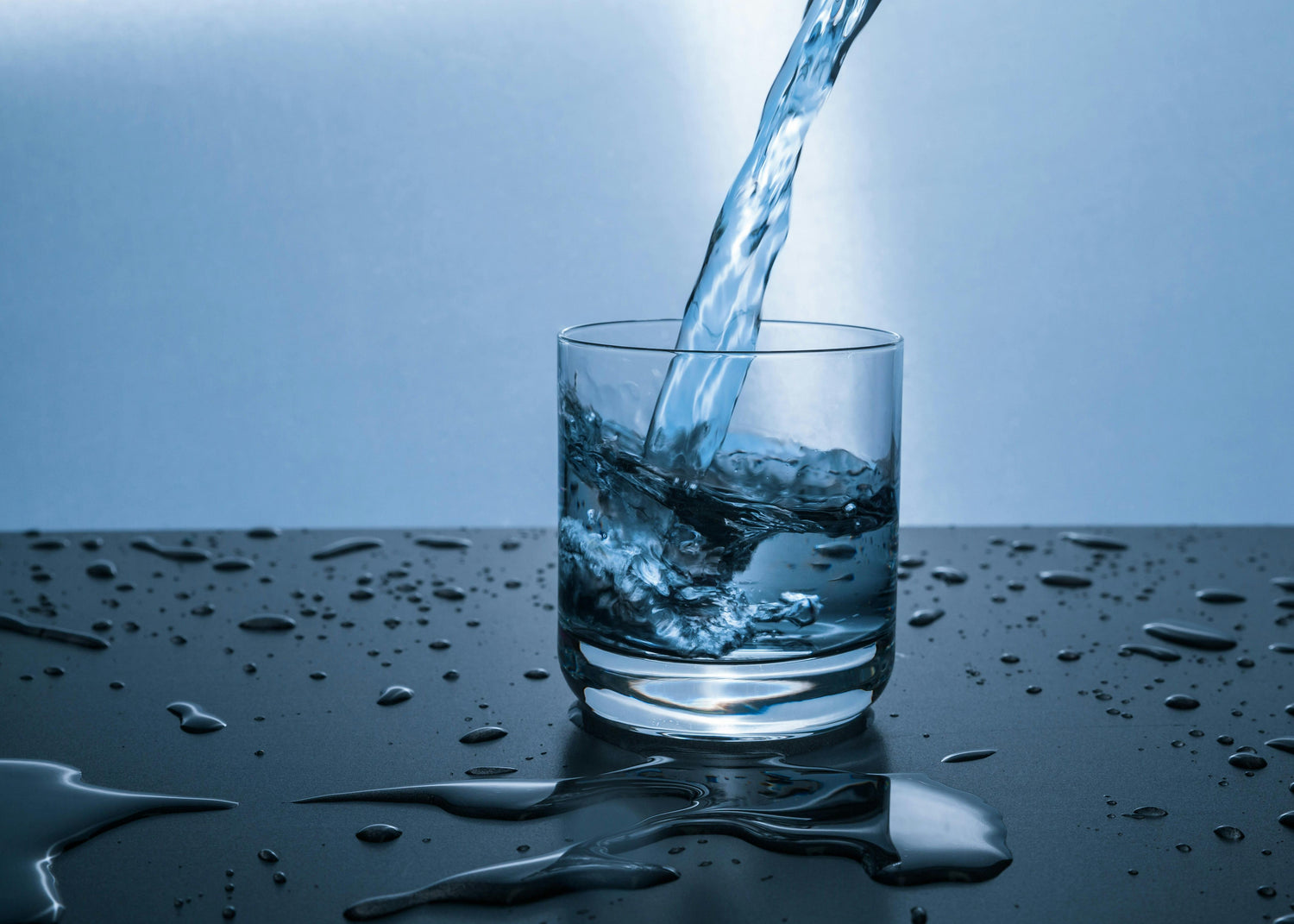 Water pouring into a glass representing hydrogen-rich hydration science